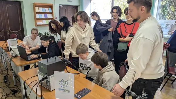 Паяльная станция и ноутбук на столе ЖукЛаба, вокруг дети и родители