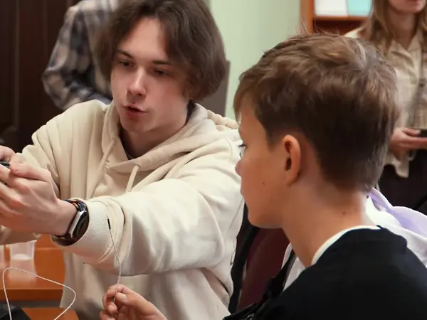Преподаватель показывает подростку, как соединить провода